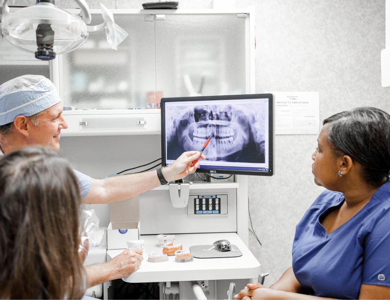 dr. seale and assistants reviewing a dental x-ray