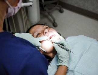 dental hygienist looking at a patient's teeth