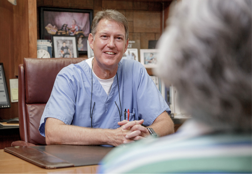 Dr. Seale at a desk speaking with a patient